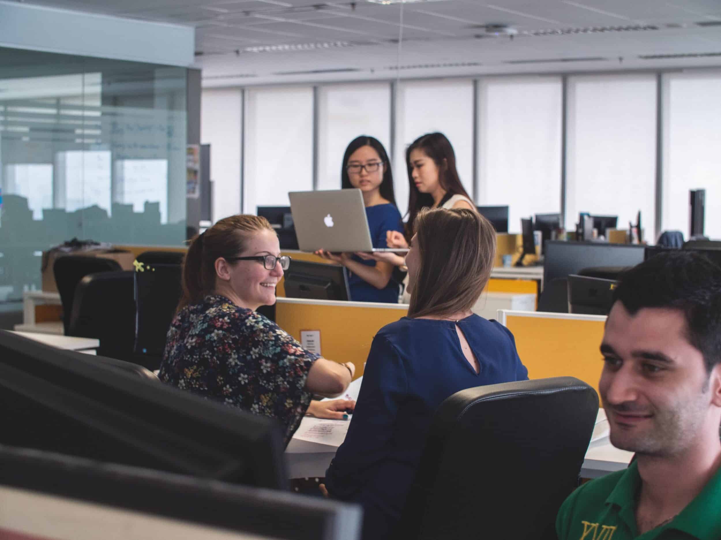 Two women are discussing about ReactJS development sitting in an office